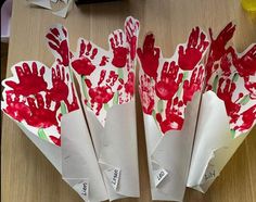 four paper flowers with hand prints on them