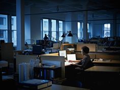 a man working on his laptop in an office at night