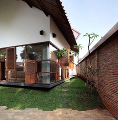 a house with wooden shutters on the outside and grass in the front yard area