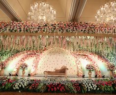 an elaborate stage decorated with flowers and chandeliers for a wedding or special event