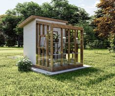 a small white shed sitting on top of a lush green field