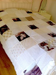 a white bed topped with a blanket covered in photos