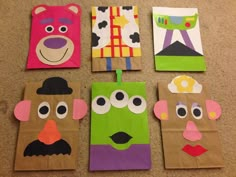 four paper bags with different animal faces on them, one is brown and the other is green