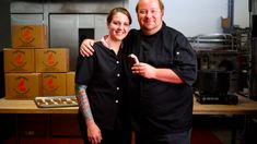 a man and woman standing next to each other in a kitchen