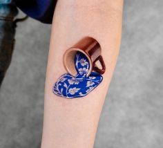 a woman's arm with two cups on it