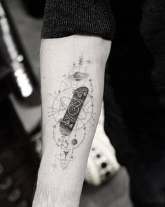 a man's arm with a tattoo on it that has an image of a skateboard