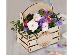 a wooden basket filled with flowers on top of a table