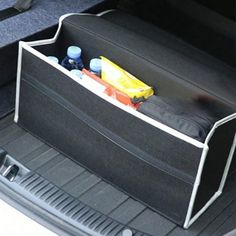 an open trunk compartment in the back of a car with bottles and other items inside