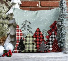 a pillow sitting on top of a wooden table next to christmas tree decorations and ornaments