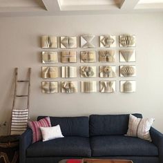 a living room with a blue couch and several mirrors on the wall above it's headboard