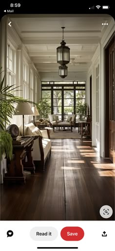 an image of a living room with wood flooring and large windows in the background