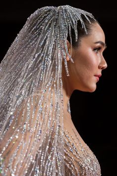 the back of a woman's head with long veil and beaded dress on