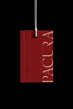 a red tag with the word aoga on it hanging from a string in front of a black background