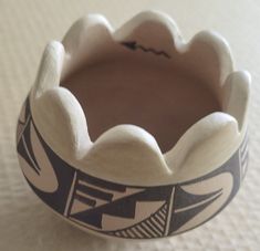 a close up of a toothbrush holder on a table with a white surface behind it