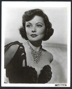 an old black and white photo of a woman in a dress with a necklace on her neck