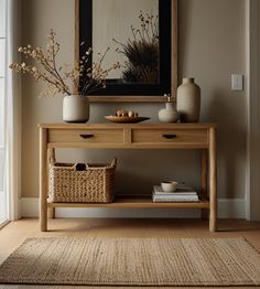 a wooden table with two vases on it and a basket under the table next to it