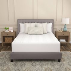 a white bed with pillows on top of it