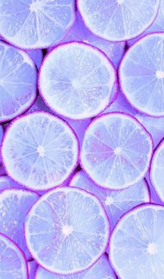 a bunch of cut up lemons sitting next to each other on a purple surface