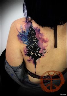 the back of a woman's neck with a tree tattoo on it