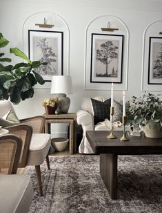 a living room with couches, chairs and pictures on the wall above them in black and white