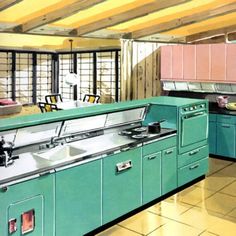 an old fashioned kitchen with green cabinets and pink cupboards on the wall, along with yellow tile flooring