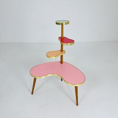 three tiered pink and gold table on white background