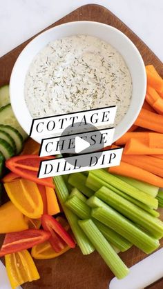 a wooden cutting board topped with veggies next to a bowl of cottage cheese dip