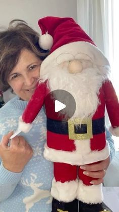 a woman is holding a stuffed santa clause