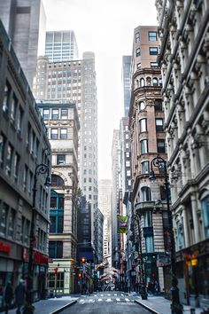 an empty city street with tall buildings in the background