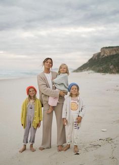 two women and three children standing on the beach