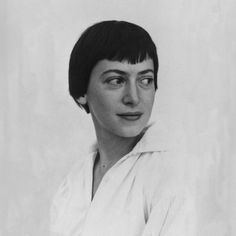 an old black and white photo of a woman with short hair, wearing a collared shirt