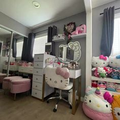 a bedroom with hello kitty decorations on the walls and desk in front of it,