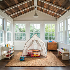 a child's play tent in the middle of a room with wooden floors and white walls