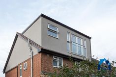 an apartment building with two windows on the top floor