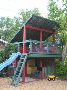 there is a play house with a slide in the yard