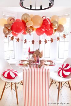 a dining room table with balloons and candy canes on the table, along with white chairs