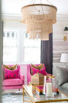 a living room filled with furniture and a chandelier hanging over the top of it