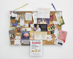 a bulletin board covered in papers and magnets