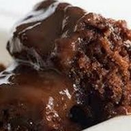 a piece of chocolate cake sitting on top of a white plate covered in frosting