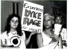 two women holding up signs and drinking coffee