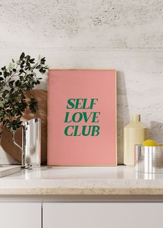 a pink poster with the words self love club on it next to some vases