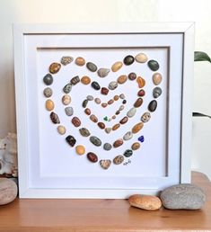 a heart made out of rocks sitting on top of a wooden table