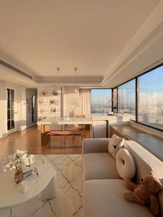 a living room filled with furniture and a large window overlooking the cityscape in the distance