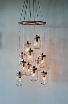 a chandelier with mason jars hanging from it's sides and lights in the middle