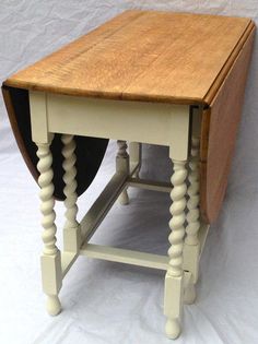 a small wooden table sitting on top of a white sheet