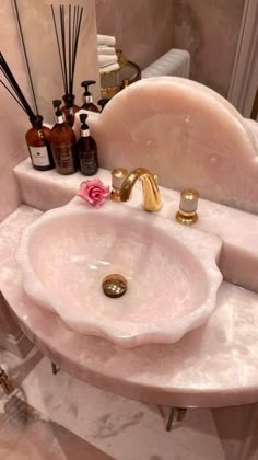 a bathroom sink with soap and lotion on it's counter top in front of a mirror