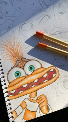 two pencils sitting on top of a paper with an image of a cartoon character