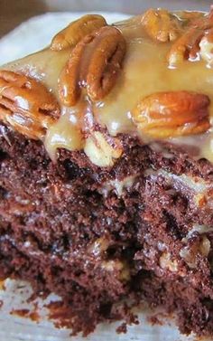 a close up of a piece of cake on a plate with pecans and icing