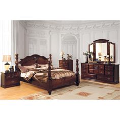 a bedroom scene with focus on the bed, dressers and mirror in the room