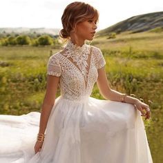 a woman in a white dress is posing for the camera with her hand on her hip